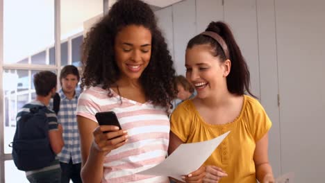Happy-students-looking-at-smartphone-at-the-university-