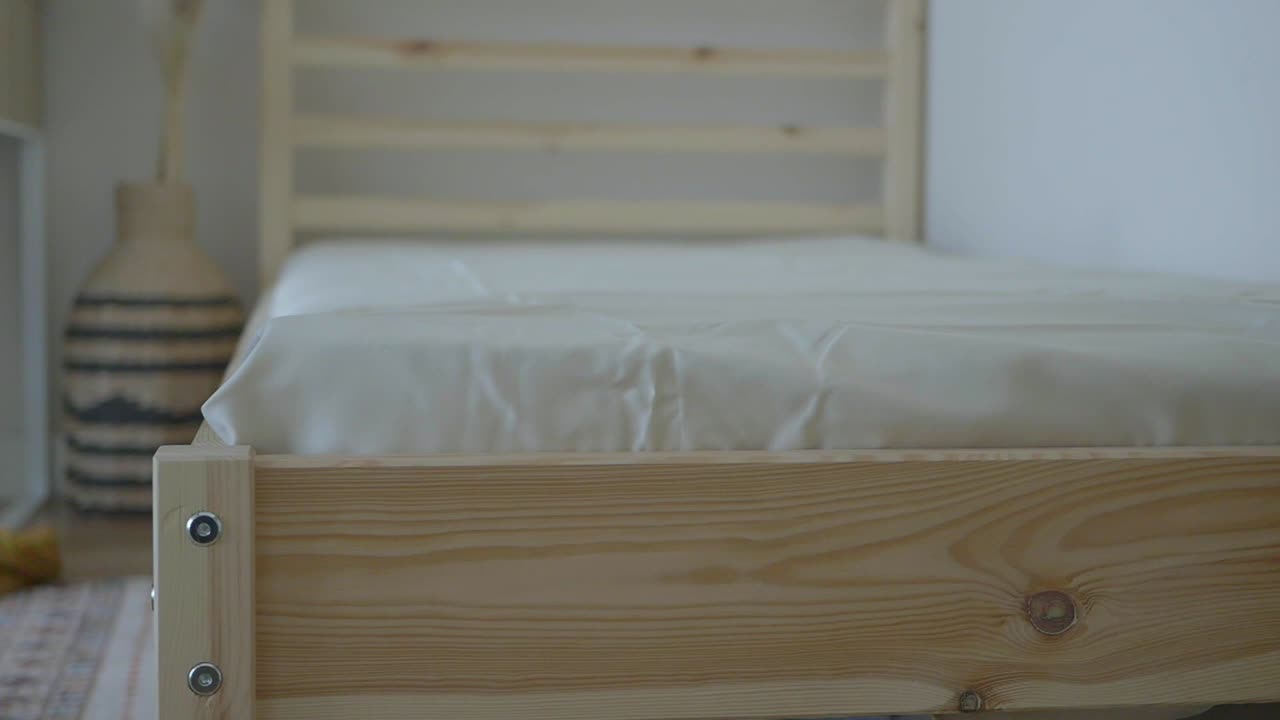 Kamar tidur dengan tempat tidur kayu dan tempat tidur berwarna putih
