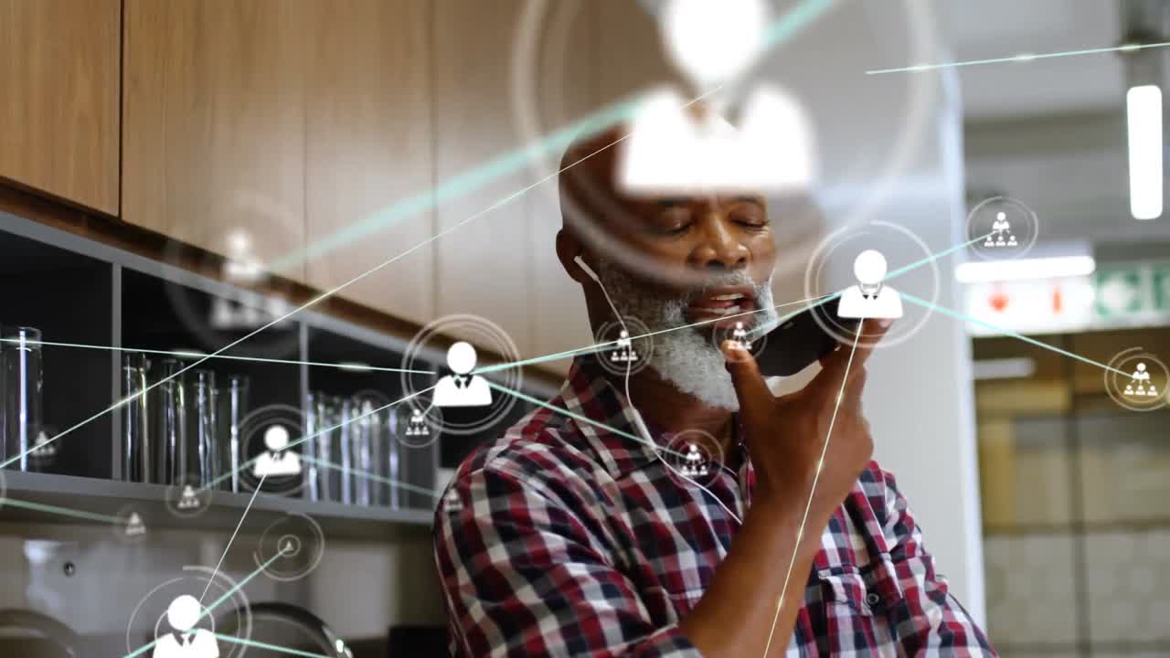 Animation of network of connections with people icons over biracial businessman using smartphone