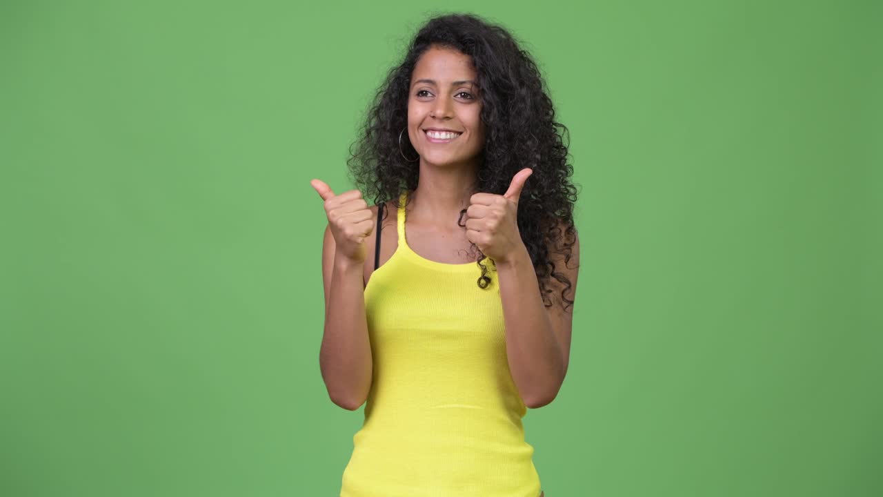 Young beautiful Hispanic woman giving thumbs up