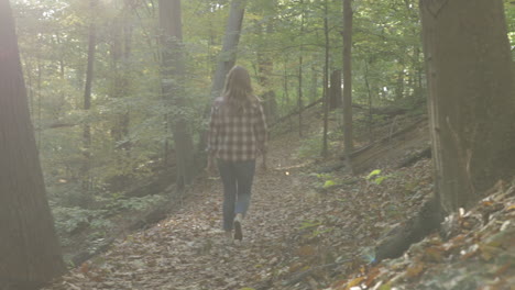 Young-woman-walking-down-a-path-in-the-woods