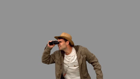 man jumping and using binoculars on grey screen