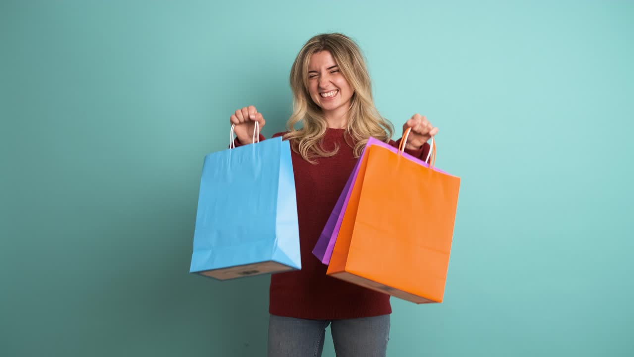 Happy woman showing colorful shopping bags in blue studio
