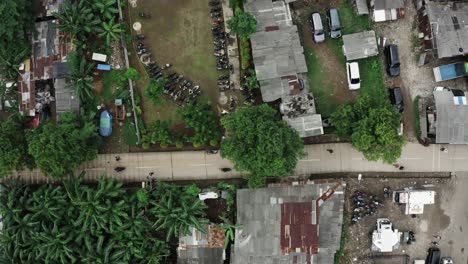 Disparo-Inclinado-Hacia-Abajo-Que-Muestra-El-Tráfico-En-Una-Carretera-Panorámica-En-Una-Zona-De-Tugurios-De-La-Ciudad-De-Yakarta,-Indonesia