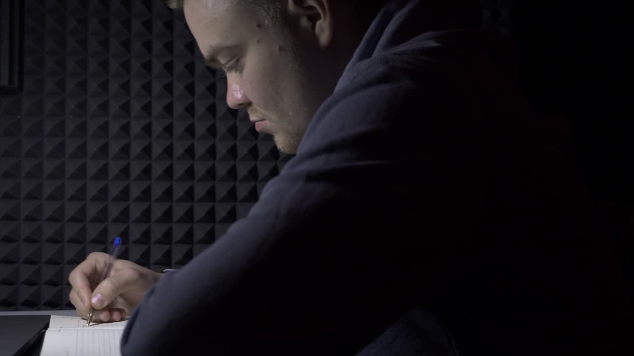hombre escribiendo en un cuaderno en casa