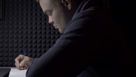 man writing in a notebook at home