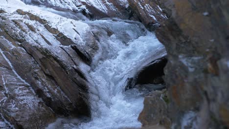 Syterbacken-cold-stream-cascading-down-rocky-landscape-in-Hemavan,-Sweden---eye-level-medium-shot