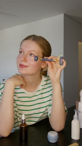 woman using a jade roller for facial massage