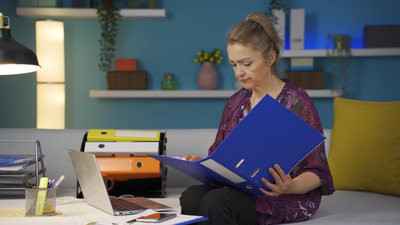 trabajadora de oficina en casa revisando archivos de papeleo.