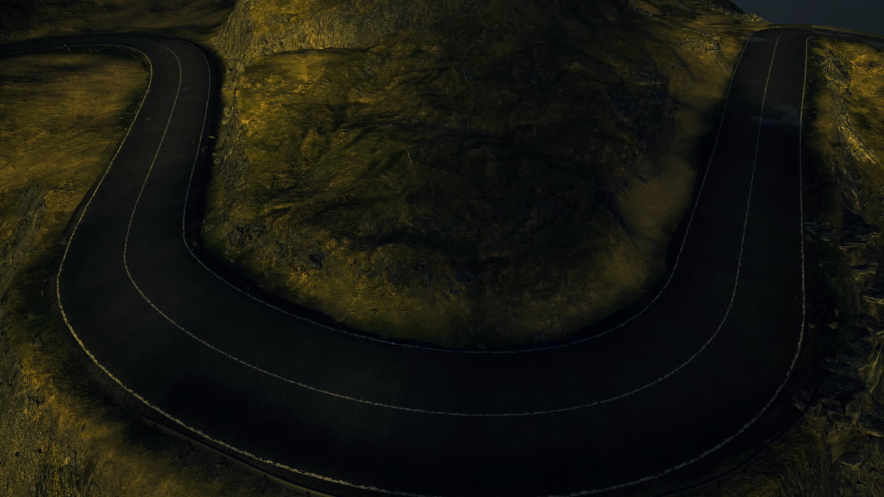 Winding mountain road during twilight near a rocky landscape