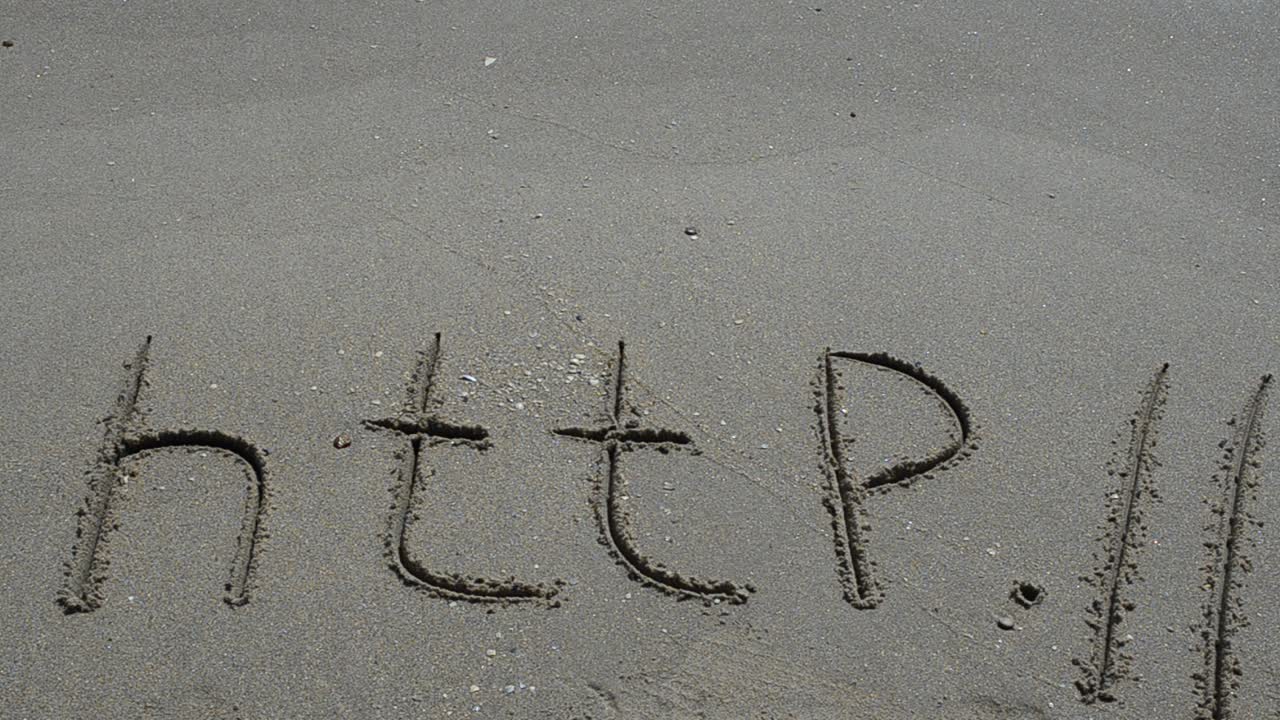 The word http handwritten in sand on a beach. Shooting on the beach