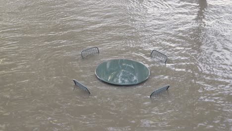 Schwere-Überschwemmung-Vom-Fluss,-Der-Tisch-Und-Stühle-Im-Freien-Eintaucht---Aus-Dem-Ursprünglichen-Blickwinkel