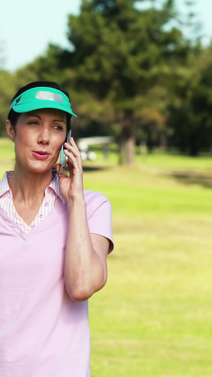Golfista donna che parla al cellulare mentre gioca a golf