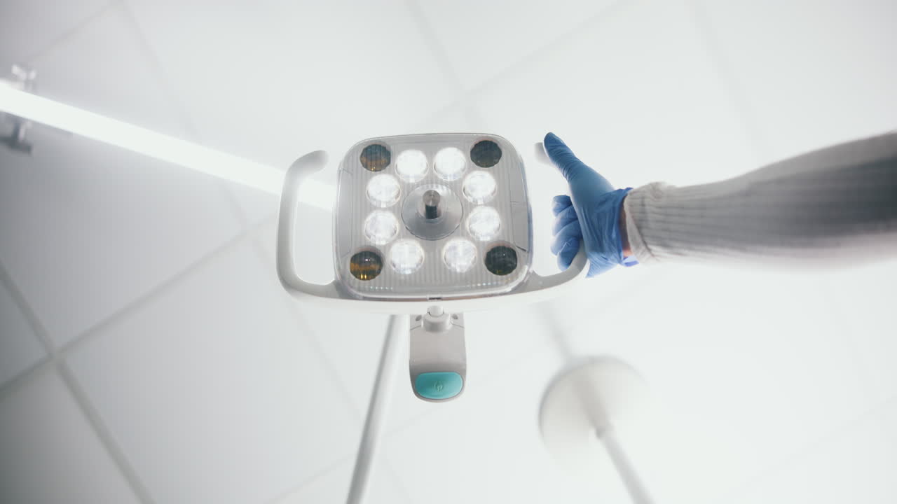 치과 의사가 치과 조명을 조정 하고 있다