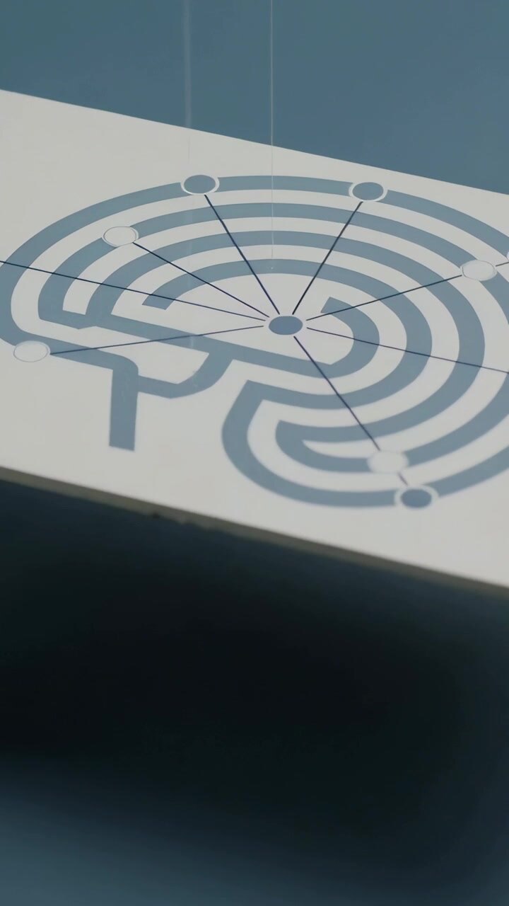 Vertical video: Panning camera revealing white card on blue tabletop, displaying maze hub and phone