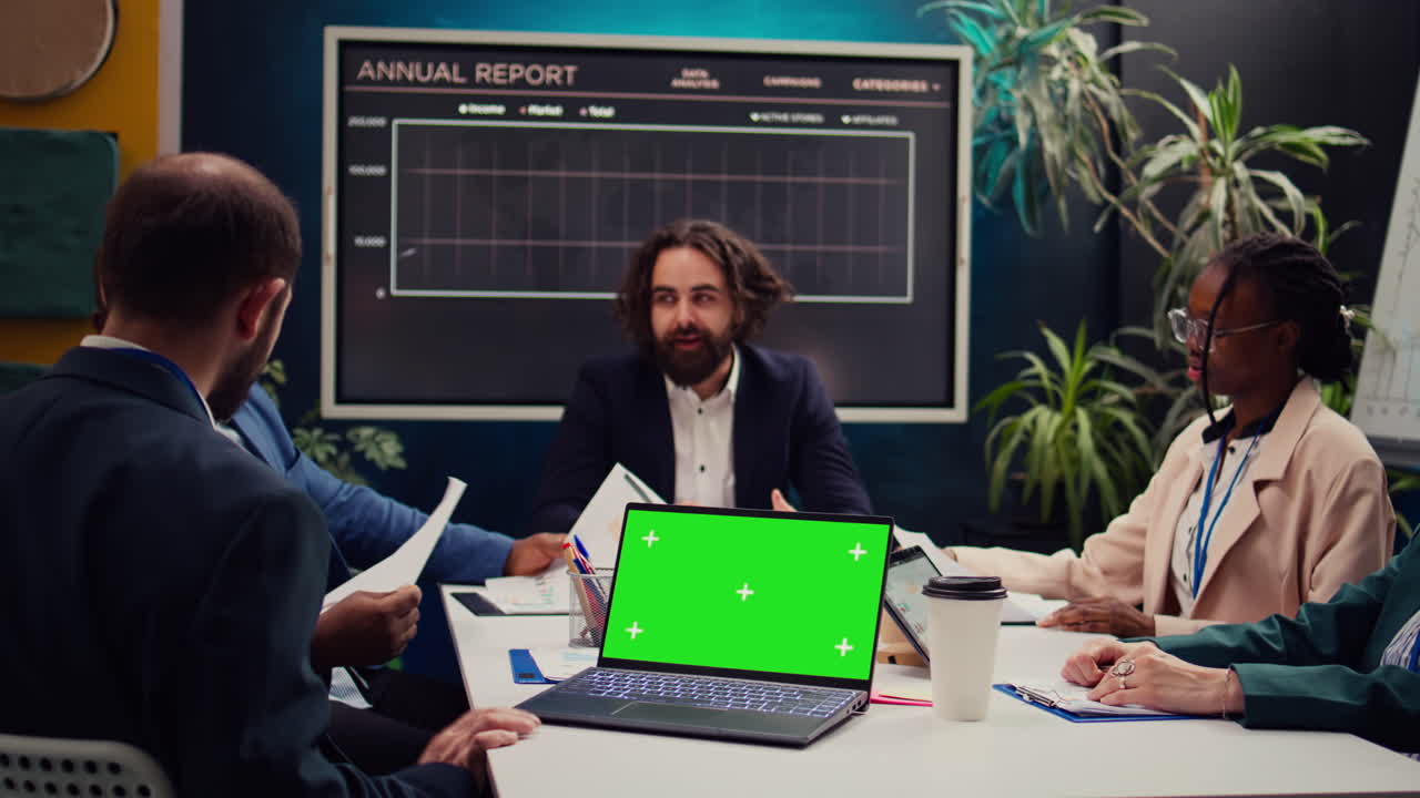 Business partners attending meeting next to greenscreen laptop