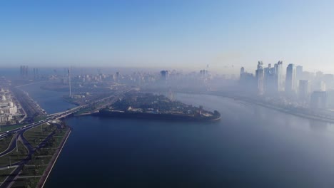 Vista-Desde-Arriba-Del-Lago-Khalid-De-Sharjah,-Ojo-De-Emiratos,-Horizonte-De-Sharjah-En-Una-Mañana-Nublada,-Niebla-En-El-Golfo,-Emiratos-árabes-Unidos,-Video-4k