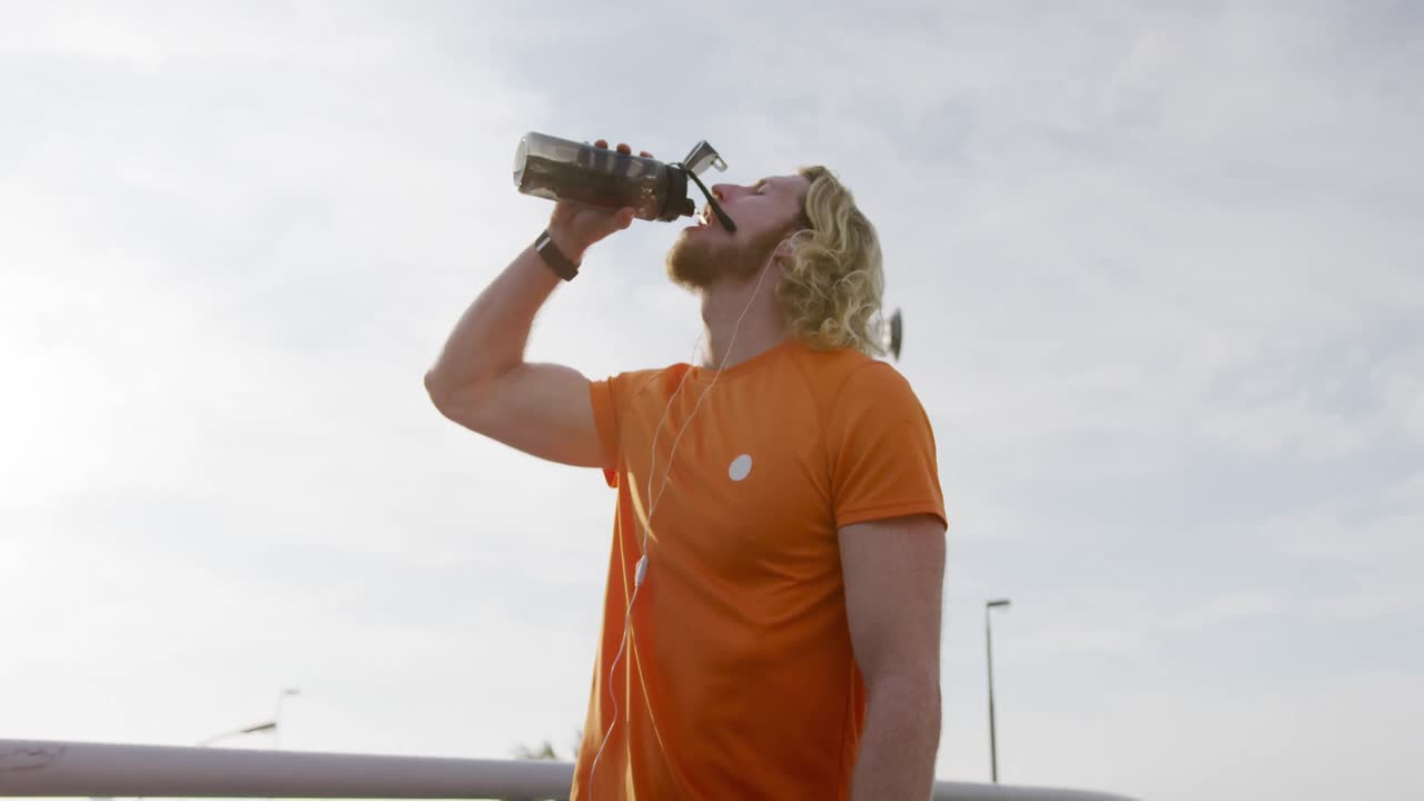 hombre caucásico deportivo bebiendo agua