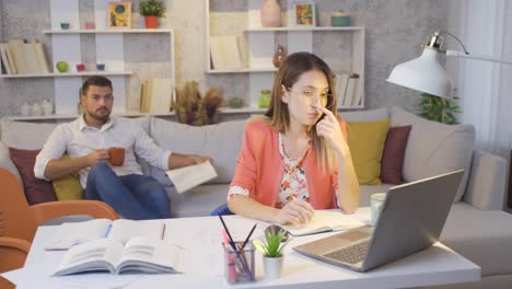 su marido ayuda a la mujer que está luchando con su trabajo.
