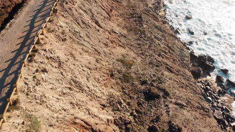 revealing aerial of portugal coastal area, hiking pathway goes along the coast with cliffs rising straight up from the beach, scenic headland coast of portugal, traveling and vacation concept