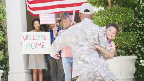 afrikanisch-amerikanischer männlicher soldat, der nach hause zurückkehrt, begrüßt von glücklichen kindern und familie, zeitlupe