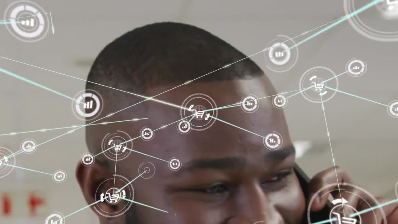 Animation of network of icons against african american businessman talking on smartphone at office