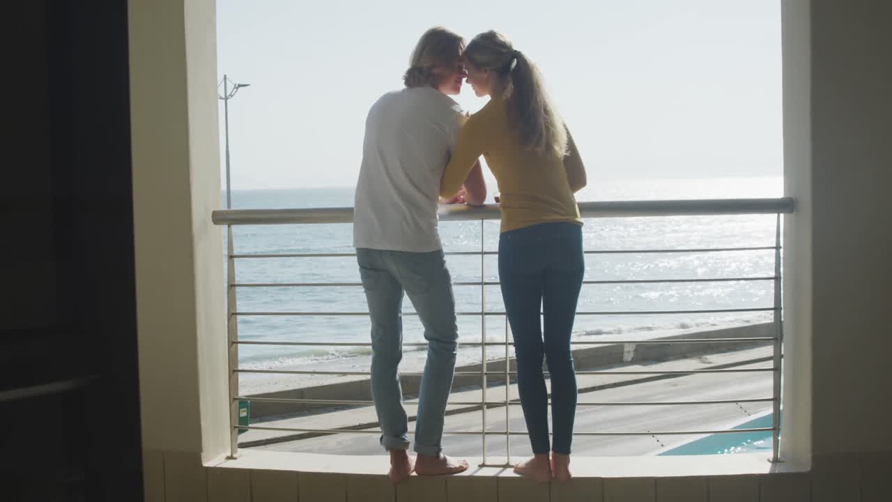 백인 부부가 바 ⁇ 가에서 시간을 즐기고 있습니다.