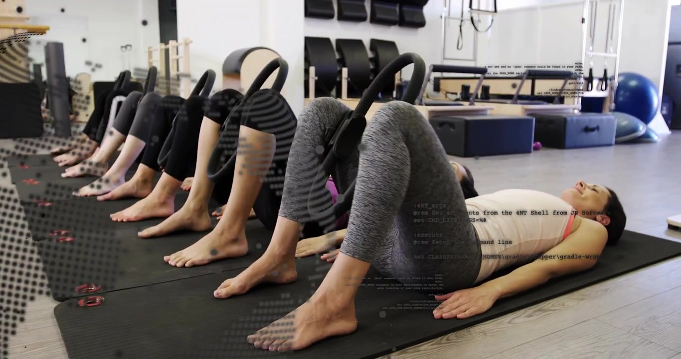 Sei donne in fila che sollevano i fianchi stringendo anelli da pilates, con una sovrapposizione grafica di un globo digitale che traccia la postura.