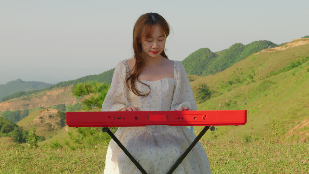 asiatic female musician artist playing piano keyboard in nature red hair girl composing new music