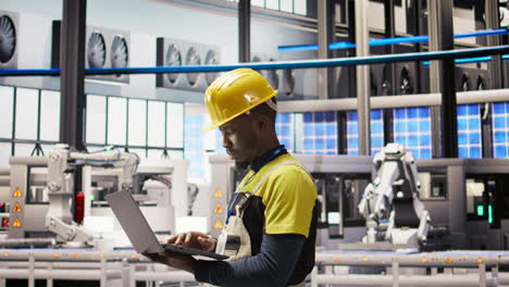 vertical video technician in smart factory using notebook to look at system performance metrics
