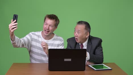 성숙한 일본 사업가와 젊은 스칸디나비아 사업가가 함께 일하고 있습니다.