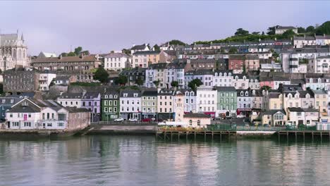 Colourful-row-of-houses-in-Cobh,-Cork-the-view-from-water,-from-a-ship-passing