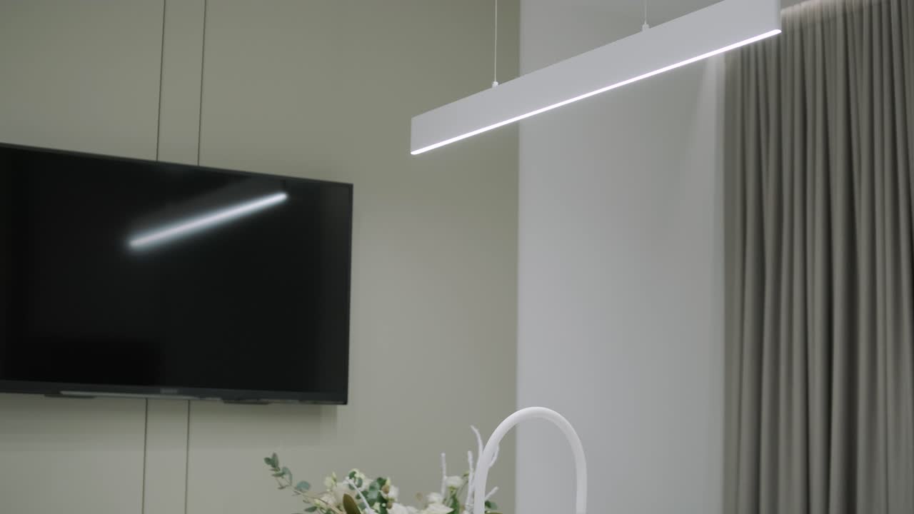 una lujosa cocina con una gran isla, un grifo de oro y una lámpara sputnik, electrodomésticos de acero inoxidable y encimeras de mármol blanco.