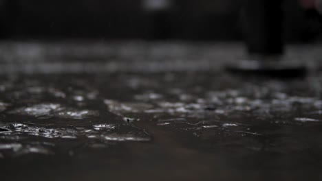 rain drops falling on ground close up, droplets splashing on stone surface