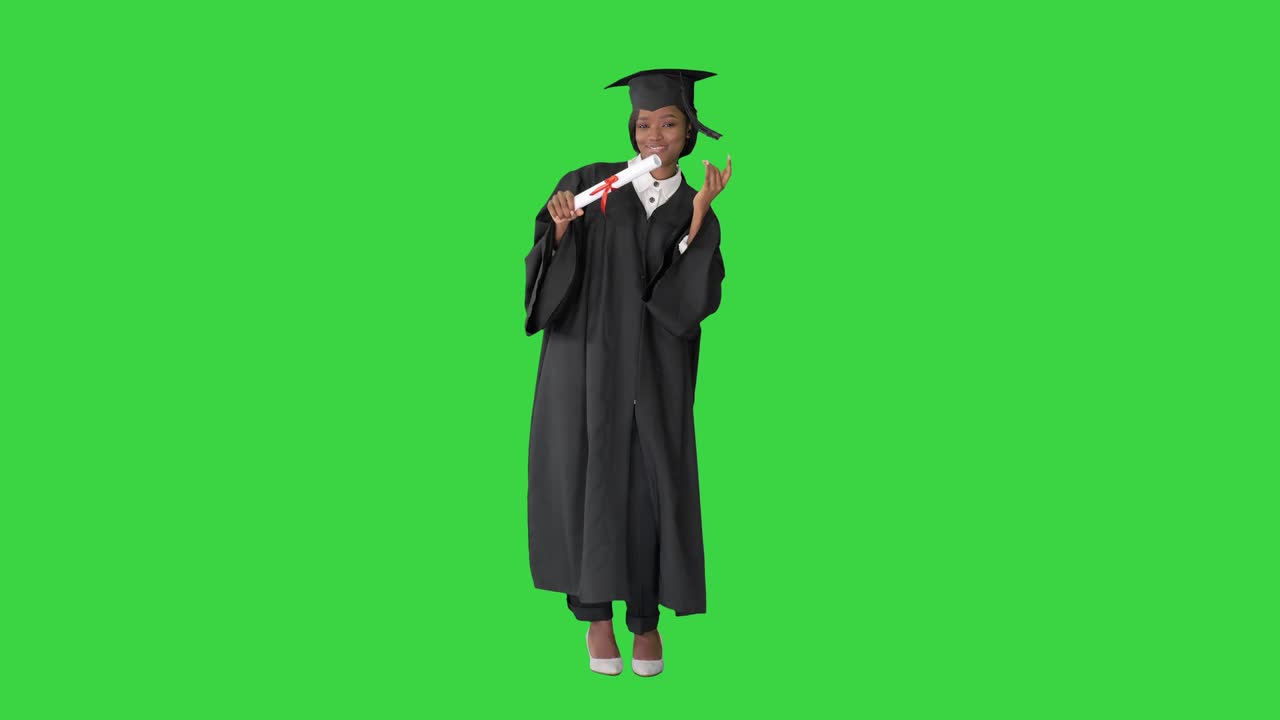Felice studentessa afro laureanda che balla su uno schermo verde, Chroma Key.