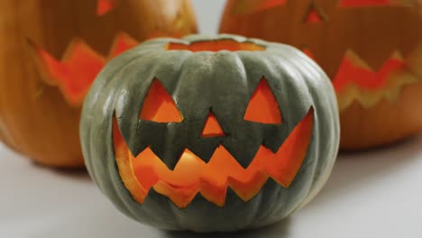 Close-up-view-of-scary-face-carved-halloween-pumpkin-against-grey-background