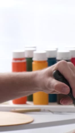 hands painting with a brush and colorful paints