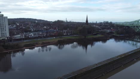 runcorn old town waterfront aerial view suburban residential property housing and church spire district slow right dolly