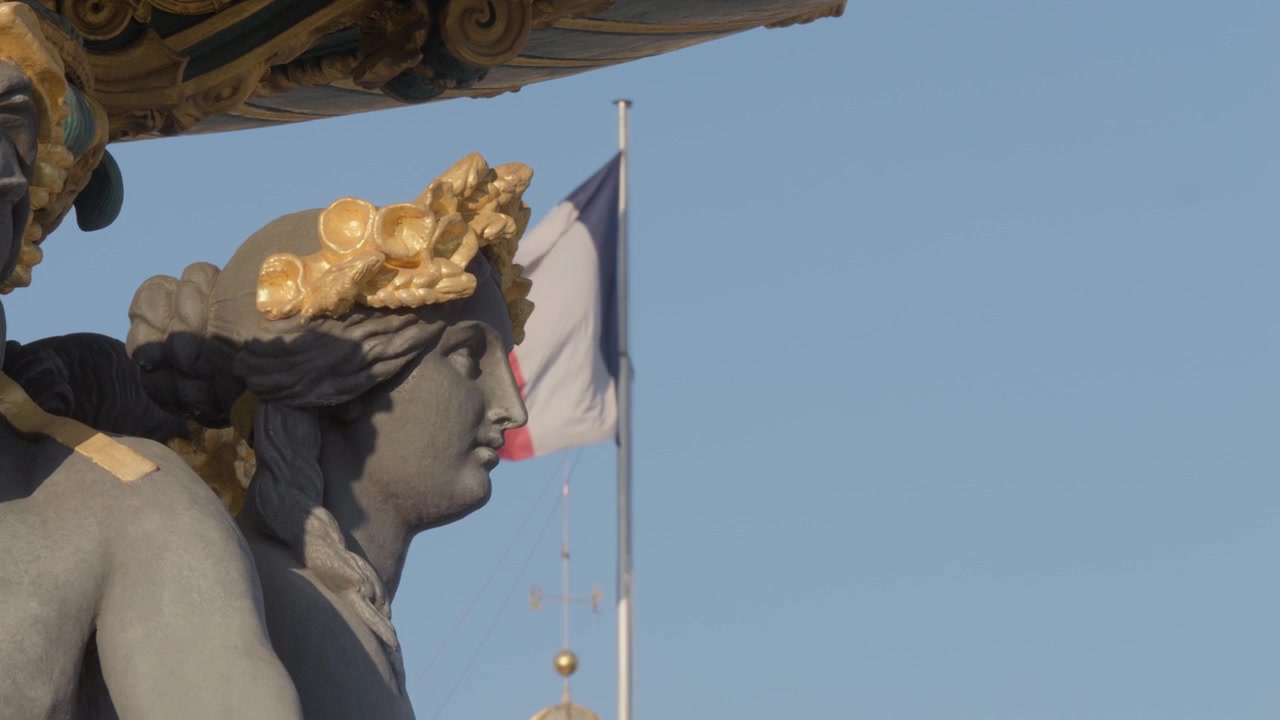 Ripresa statica al rallentatore di una statua allegorica dorata sulla Fontaine des Mers a Place de la Concorde a Parigi, con la bandiera francese che sventola dietro di essa.