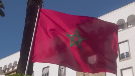 hermosa bandera marroquí en cámara lenta frente a edificios antiguos en rabat