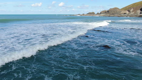 toma aérea sobre las olas en el mar en la playa costera de spekes mill en devon