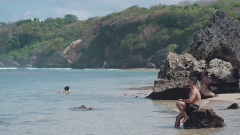 man relaxing on beach rocks