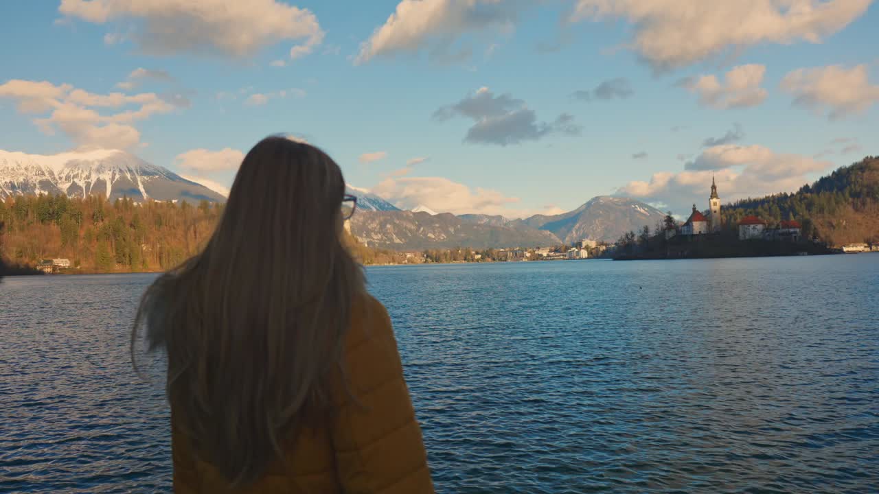 4K video of a beautiful young caucasian female looking over at the island with the church on it