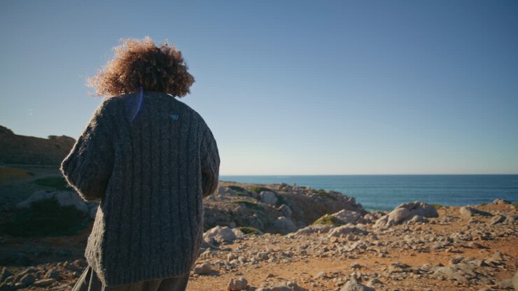 Relaxed brunette strolling rocky landscape walking abandoned nature rear view