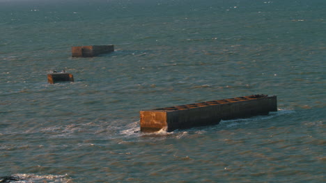 view of world war ii phoenix blocks , artificial mulberry harbours , normandy landings in june 6, 1944 d-day, pointe du hoc, arromanches