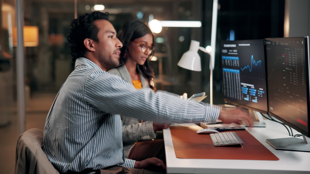 Business Professionals Collaborating and Analyzing Data on Computer Screens in Office
