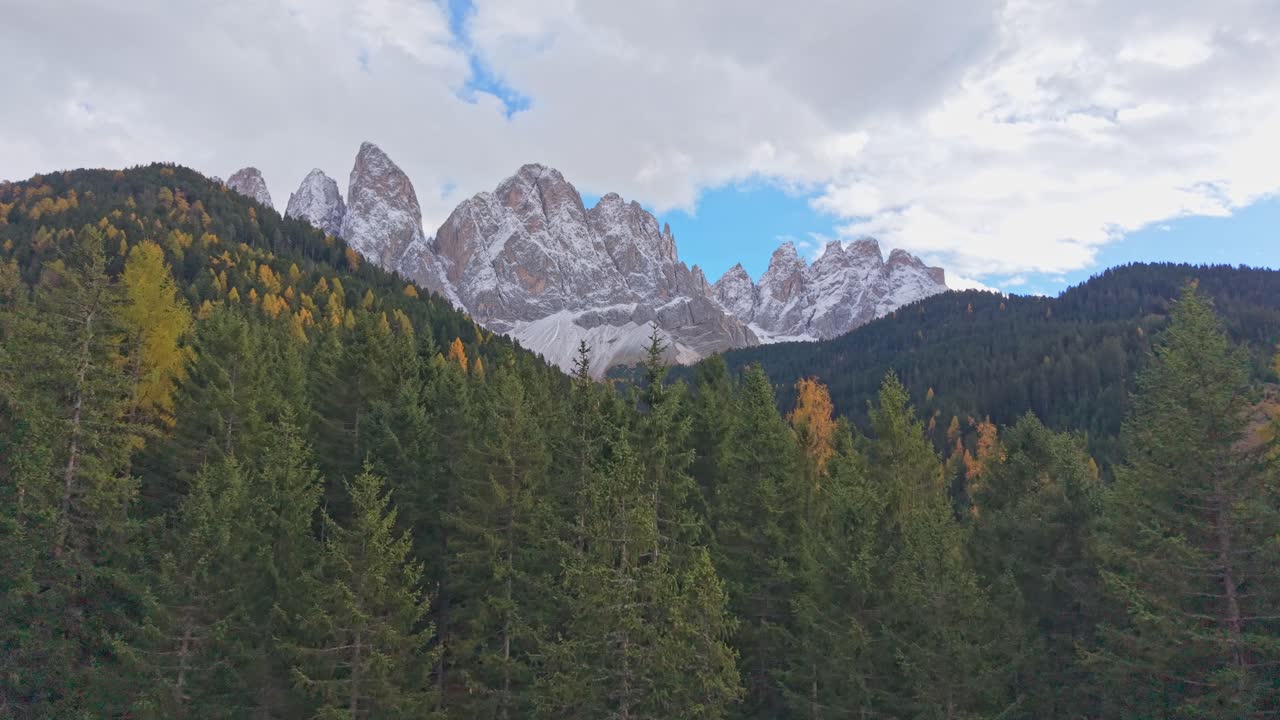 Smukt dronebillede af Dolomitternes bjergtop og lyse efterårstræer, Italien
