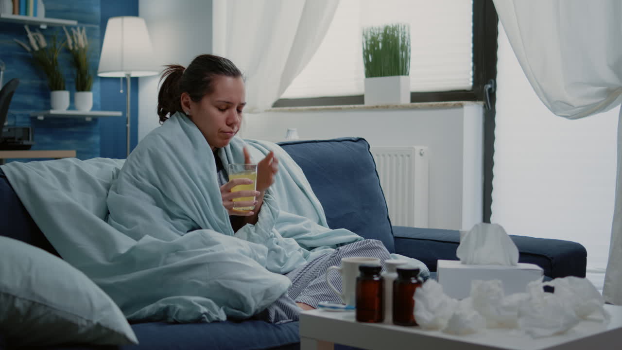 Woman with flu drinking effervescent medication with water