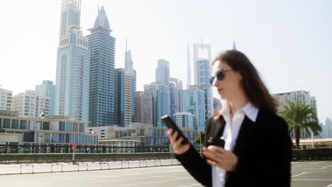 Elegant-businesswoman-with-phone-outdoors