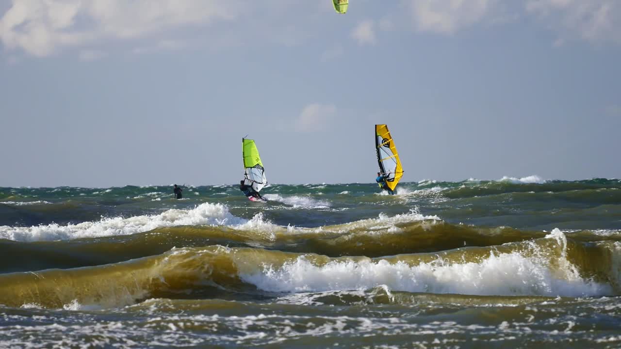 windsurfistas surfeando en altas olas del mar báltico en polonia